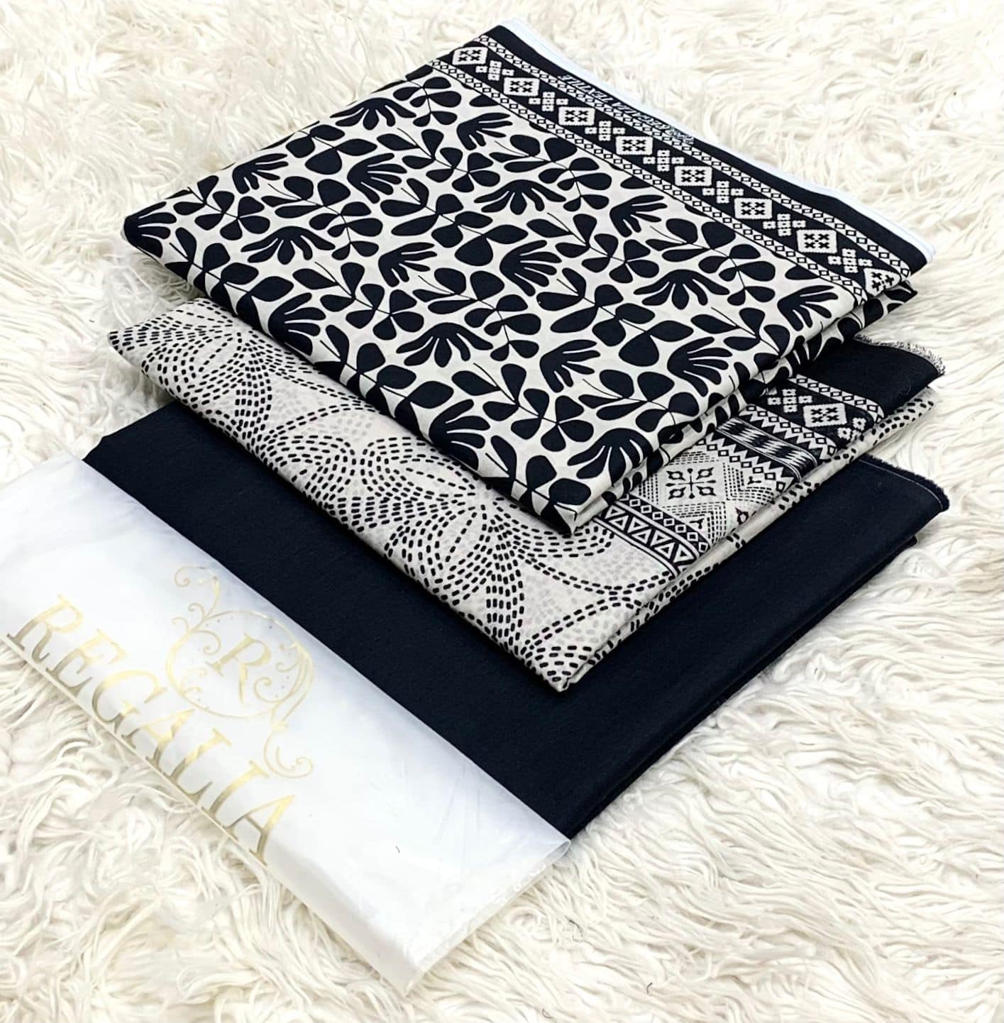 EGALIA-BLACK & WHITE-SERIES 2026 4 Black and white patterned traditional attire, neatly folded on a soft surface.
